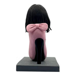 Niestandardowa elegancka dama Bobblehead siedząca na wysokich obcasach